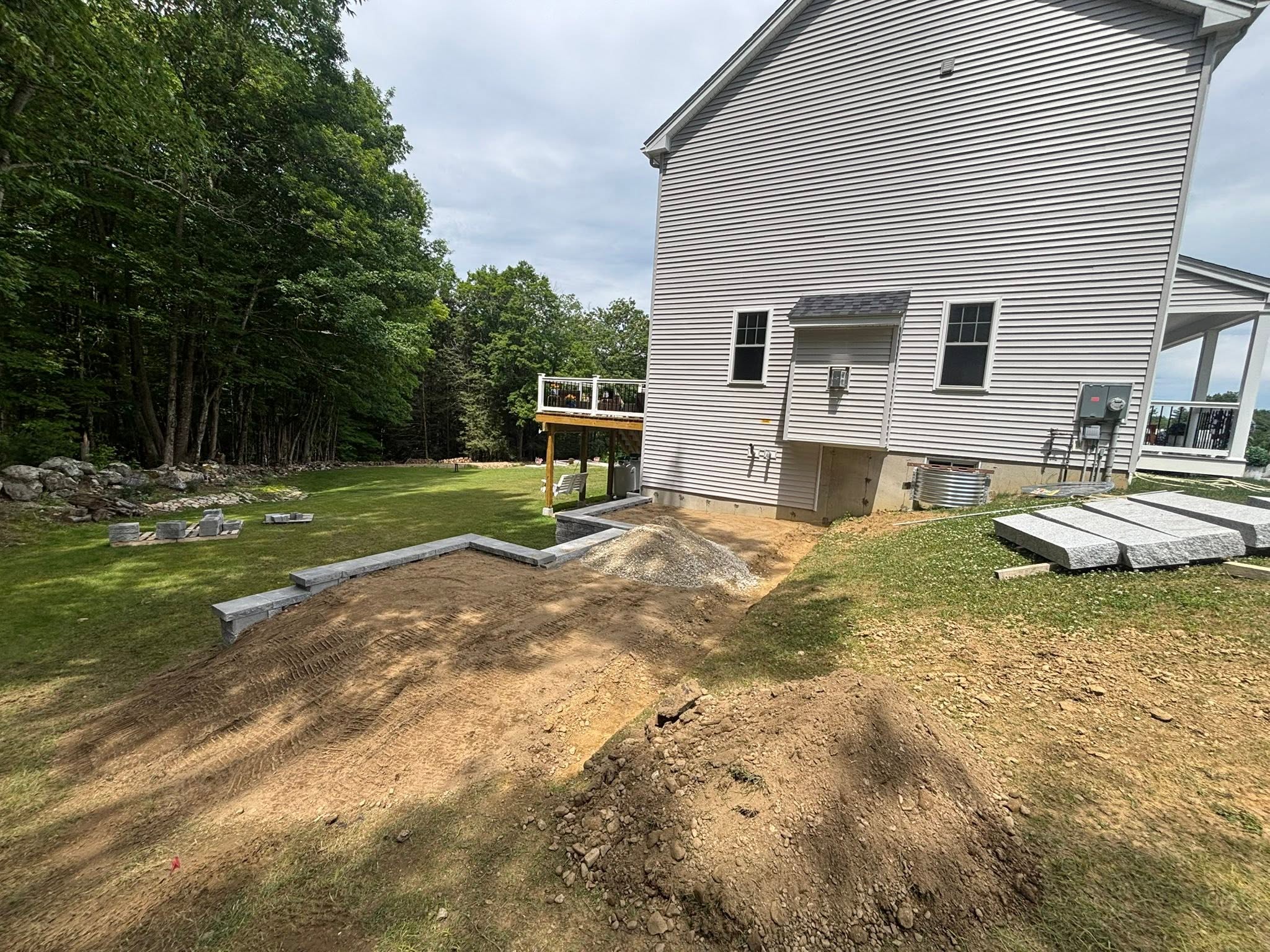 Retaining wall nearly complete — stone coursework in progress